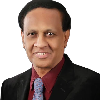 Studio portrait of Dr. D. A. Satish in a dark blazer and tie.